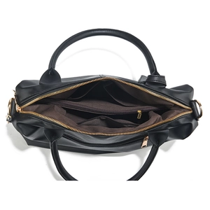 Detail view of the spacious black tote bag interior with multiple compartments and gold hardware