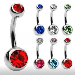 Macro detail of multi-color crystal belly button rings in a stainless steel piercing set