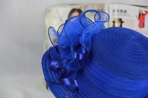 Close-up of royal blue organza sun hat with layered mesh flowers and feather accents