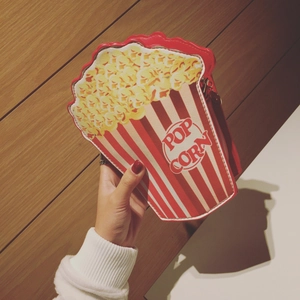 Detail showing red and white striped popcorn crossbody bag with POP CORN text