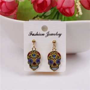 Detail of yellow candy skull drop earrings with colorful enamel floral patterns