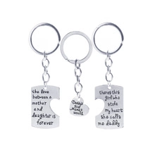 Macro detail of silver stainless steel family keychains with engraved heart cutouts