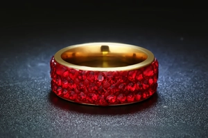 Macro shot of gold stainless steel ring featuring three rows of pavé red rhinestones