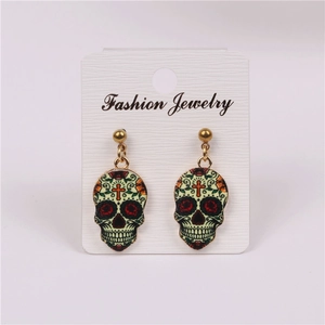 Detail of punk skull earrings with colorful floral enamel patterns on a display card