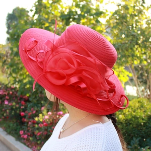 Close-up of elegant red organza flower on a wide brim sun hat for wedding events
