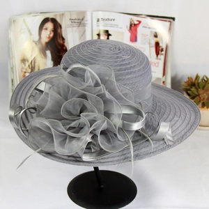 Detail of grey sun hat featuring elegant organza flowers and feather accents