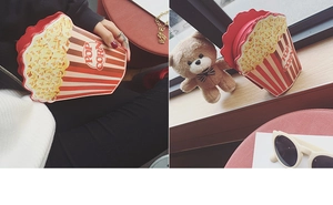 Detailed view of novelty popcorn bucket crossbody bag with red and white stripes and gold chain