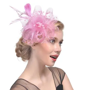 Chapeau fascinateur rose avec plumes, voile et perles sur un modèle vu de profil