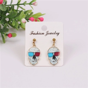 Macro detail of punk skull earrings featuring newspaper print design and colored glasses