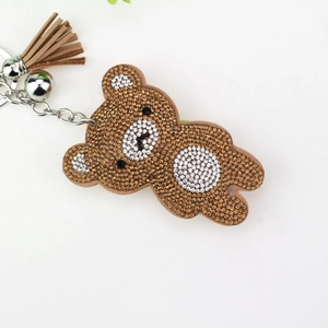 Detailed macro view of rhinestone bear keychain with brown crystals and leather tassel