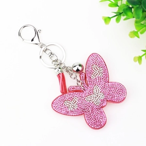 Pink rhinestone butterfly keychain with velvet backing and decorative tassel on white background
