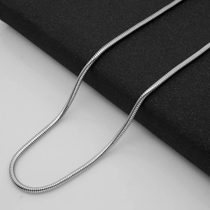 Macro detail of the polished silver snake chain necklace featuring a smooth metallic texture