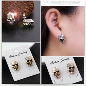 Close-up of sparkling skull earrings in silver, gold, and rose gold with pavé crystals
