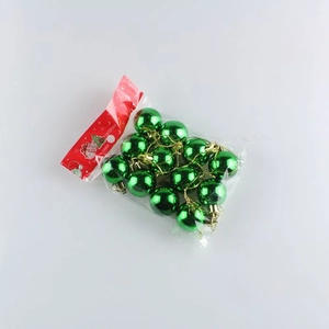 Detailed view of 12 green electroplated Christmas balls in transparent packaging with gold hooks