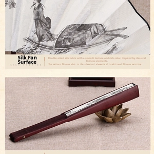 Detail of silk fabric fan face with traditional Chinese landscape painting and bamboo ribs