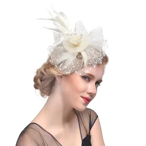 Détail d'un fascinateur blanc avec fleurs en dentelle, plumes, perles et voile à pois