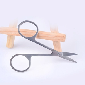 Brushed stainless steel beauty scissors for eyebrow and nail grooming on light gray background