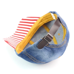 Denim baseball cap with red striped brim and yellow lining seen from a top side view
