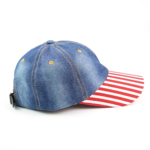 Detailed side view of a denim baseball cap featuring red and white striped brim