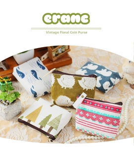Flat lay of linen coin purses with animal prints and patterns on a lace background