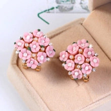 Roze bloemenoorbellen met parels en kristallen in een beige fluwelen geschenkdoos