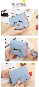 Detail view of pink and blue bifold wallet with cat ear gold buckle and tassel