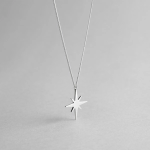 Close-up of a silver octagonal star pendant with a minimalist matte finish O-chain