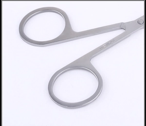 Macro view of stainless steel beauty scissors showing matte finish and material hallmark