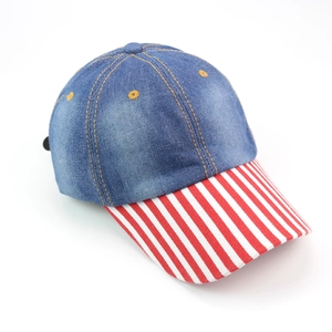 Detail view of denim baseball cap with red and white striped brim and visible stitching