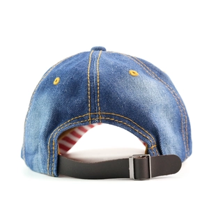 Detail of vintage washed denim baseball cap featuring leather strap and metal buckle closure