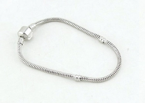 Detailed close-up of a silver snake chain bracelet with a cylindrical clasp closure