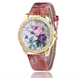 Detail of rose gold watch bezel with rhinestones and pink floral dial on leather strap