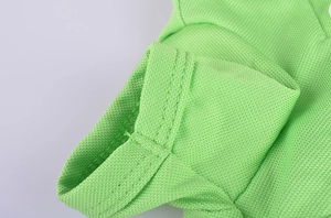 Detailed macro view of green knit pet polo shirt showing breathable mesh fabric and stitching