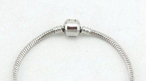 Macro shot of silver snake chain bracelet with mechanical cylinder clasp for DIY beads