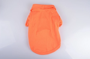 Detail view showing the knitted texture of the orange pet polo shirt on a grey background