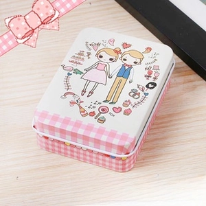 Close-up of a rectangular tin box with pink plaid patterns and cartoon couple illustration