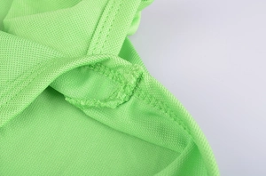 Detail of neon green breathable mesh fabric with high-density overlock stitching for dog polo