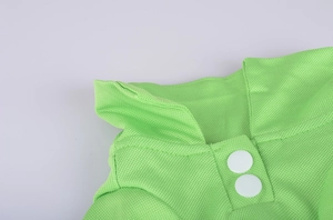 Close-up of bright green dog polo shirt featuring mesh fabric and white button details