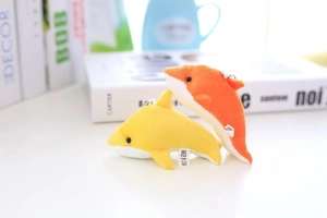 Détail de pendentifs dauphins en peluche jaunes et oranges avec porte-clés argentés