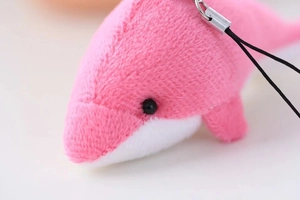 Détail de porte-clés dauphin en peluche rose avec texture douce et crochet en métal