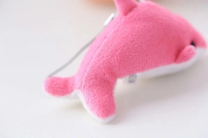 Détail du porte-clés dauphin en peluche rose avec ventre blanc et fermoir mousqueton