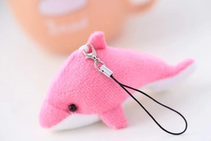 Détail du pendentif dauphin en peluche rose et blanc avec texture douce et fermoir argenté