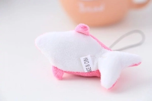 Détail d'un porte-clés dauphin en peluche rose et blanc avec cordon et étiquette
