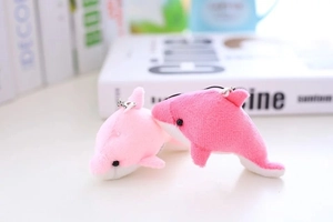 Détail de pendentifs dauphins en peluche rose avec boucles en métal argenté