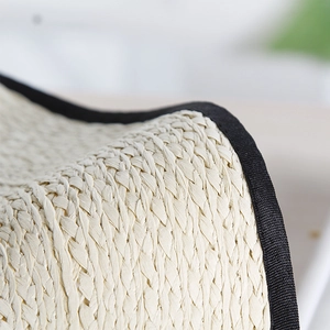Detailed macro view of woven straw texture with a contrast black fabric edge binding