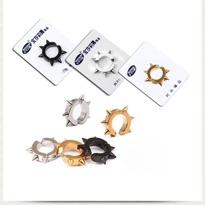 Détail de boucles d'oreilles clip punk à pointes en noir, or et argent sans perçage