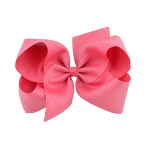 Detailed view of a large bright pink grosgrain ribbon hair bow with layered design