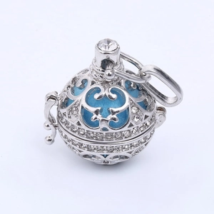 Pendentif ciselé argenté avec cristaux et boule d'harmonie bleu clair à l'intérieur