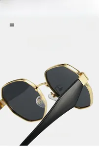Macro detail of polygon metal sunglasses featuring golden frames and elastic black temples