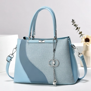 Elegant light blue structured handbag with silver metal bar and diamond tassel charm